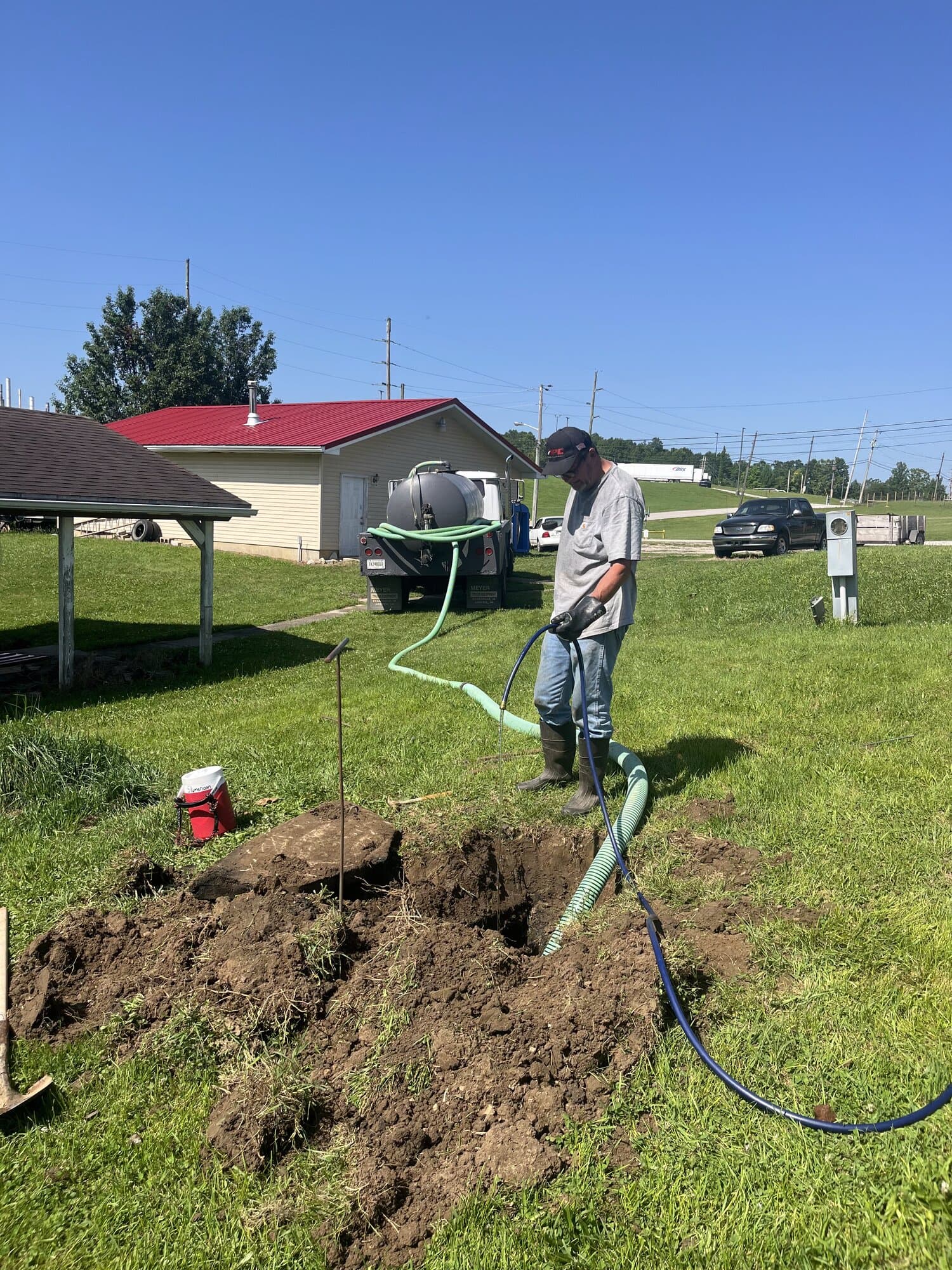 Quick Pump and Clean crew member pumping a septic tank on a residential property